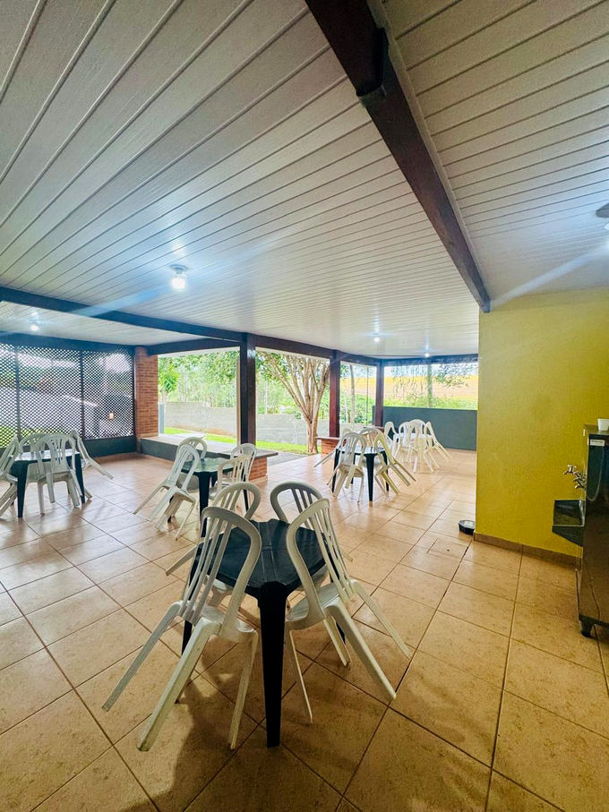 Ambiente coberto com mesas e cadeiras para convivência